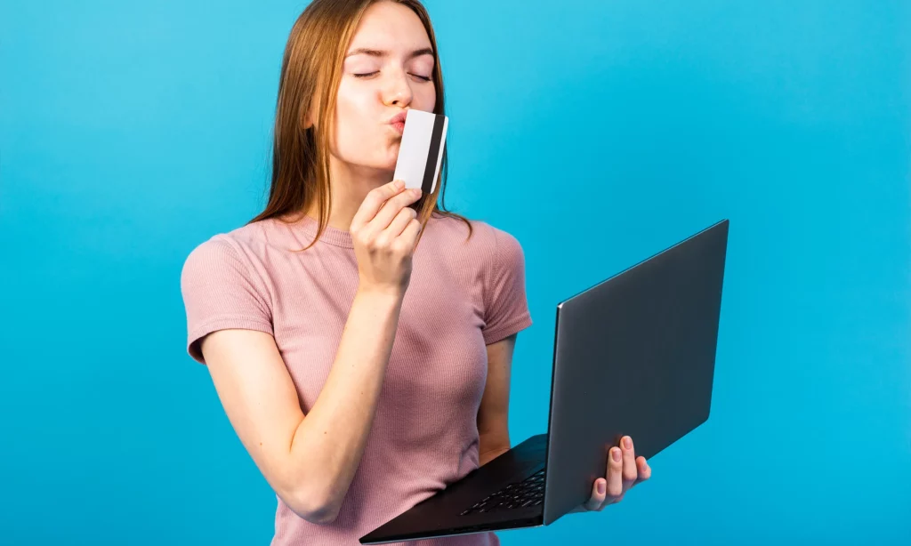 Different Types of Phishing Techniques a female hacker holding a laptop and kissing an atm card