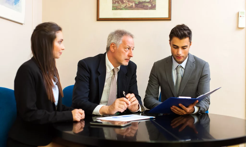 LPO benefits australian legal market male solicitor is having a discussion with his female paralegal and male document specialist