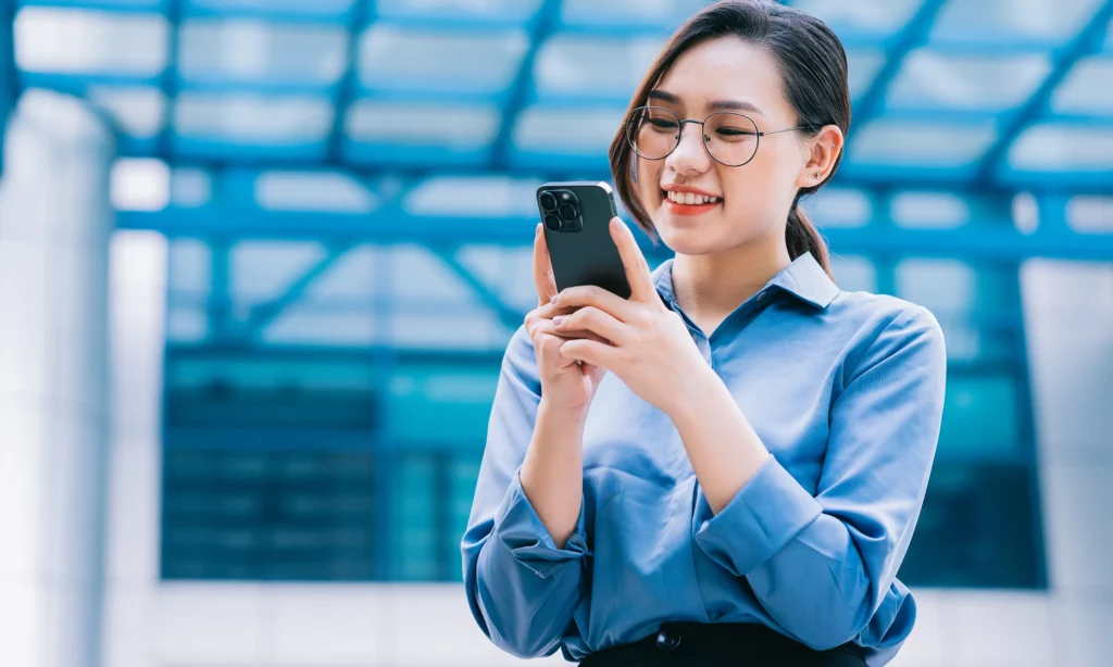 outsource social media management a female social media management expert checking a post on her mobile phone