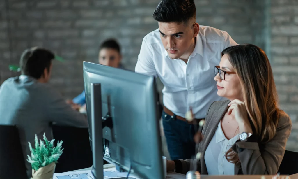 proactive cybersecurity mindset a male IT support staff checking an issue on a female employee's workstation