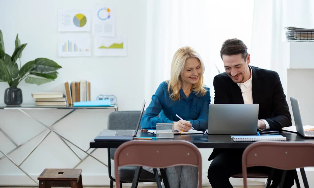 Outsourcing trends in 2020 couple who are also business owners check the cost savings they have gained on their small business through outsourcing